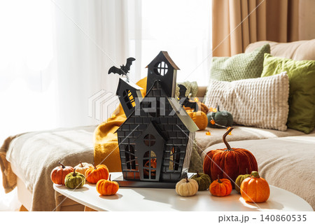 Haunted house centerpiece with Halloween pumpkins decorating cozy home 140860535