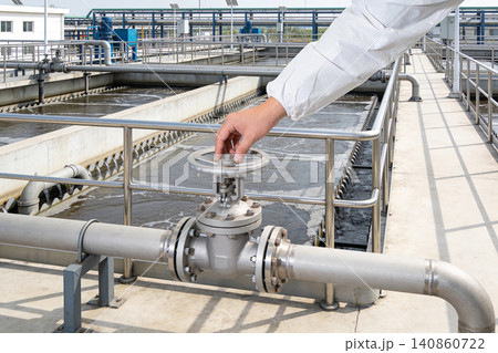 Operator adjusts valve at industrial water treatment plant for purification process Operator adjusts valve at industrial water treatment plant for purification process 140860722