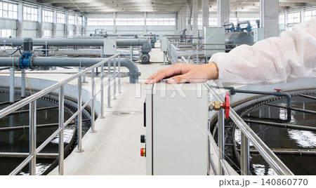 Industrial water treatment plant with operator overseeing operations and complex piping systems Industrial water treatment plant with operator overseeing operations and complex piping systems 140860770