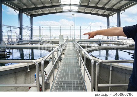 Industrial water treatment plant with circular clarifier tanks and a walkway Industrial water treatment plant with circular clarifier tanks and a walkway 140860790