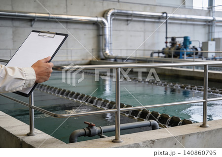 Water treatment plant inspection with clipboard and industrial equipment Water treatment plant inspection with clipboard and industrial equipment 140860795