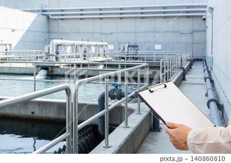 Water treatment plant inspection with clipboard and protective clothing Water treatment plant inspection with clipboard and protective clothing 140860810