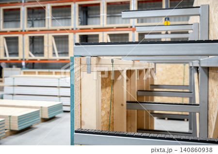 Modern warehouse interior with stacked construction materials and industrial shelving units Modern warehouse interior with stacked construction materials and industrial shelving units 140860938