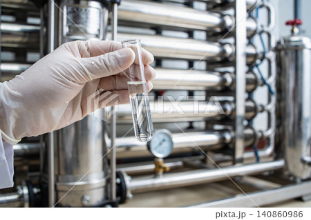 Scientist examines clear liquid in test tube at water purification plant Scientist examines clear liquid in test tube at water purification plant 140860986