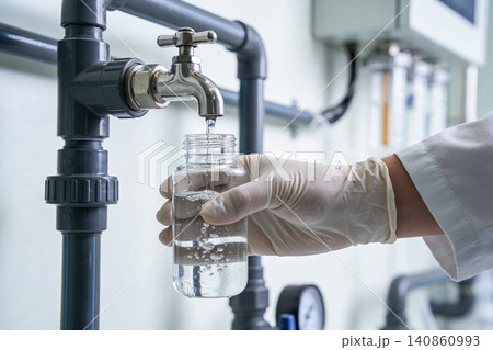 Scientist collecting water sample from laboratory faucet for analysis Scientist collecting water sample from laboratory faucet for analysis 140860993