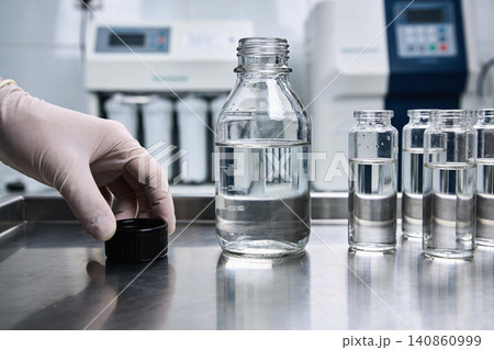 Scientist in glove prepares samples in laboratory with scientific equipment Scientist in glove prepares samples in laboratory with scientific equipment 140860999