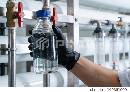 Scientist holding a bottle of purified water in a laboratory setting Scientist holding a bottle of purified water in a laboratory setting 140861000