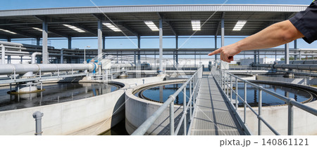 Industrial wastewater treatment plant with circular clarifier tanks and pointing finger Industrial wastewater treatment plant with circular clarifier tanks and pointing finger 140861121