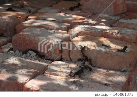 Old red bricks stacked outdoors with shadows Old red bricks stacked outdoors with shadows 140861373