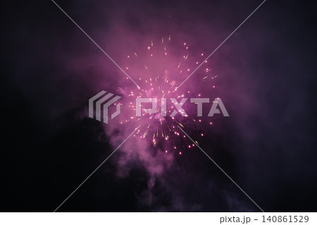 Vivid Purple Pink Fireworks Explosion Bursting Against Dark Night Sky with Smoke Vivid Purple Pink Fireworks Explosion Bursting Against Dark Night Sky with Smoke 140861529