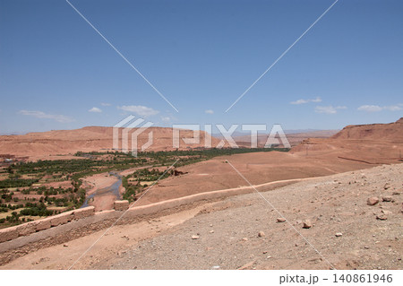 The vast red clay desert stretches out beneath the blue sky near Ait Benhaddou, Morocco. The vast red clay desert stretches out beneath the blue sky near Ait Benhaddou, Morocco. 140861946