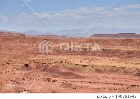 The vast red clay desert stretches out beneath the blue sky near Ait Benhaddou, Morocco. The vast red clay desert stretches out beneath the blue sky near Ait Benhaddou, Morocco. 140861948