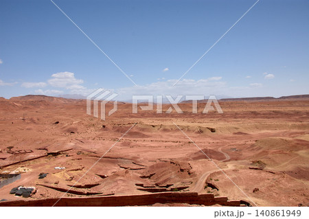 The vast red clay desert stretches out beneath the blue sky near Ait Benhaddou, Morocco. The vast red clay desert stretches out beneath the blue sky near Ait Benhaddou, Morocco. 140861949