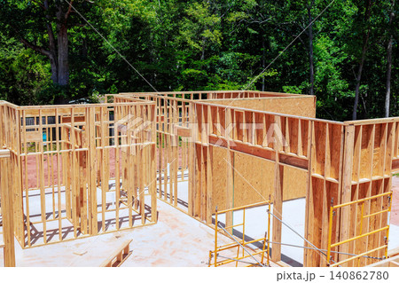 Workers build wooden beams frames for structure framing stage unfinished house Workers build wooden beams frames for structure framing stage unfinished house 140862780