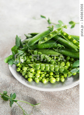 Fresh green peas pods on rustic plate Fresh green peas pods on rustic plate 140863008