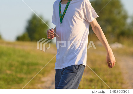 Person wearing sunflower lanyard indicating hidden disability walking outdoors Person wearing sunflower lanyard indicating hidden disability walking outdoors 140863502