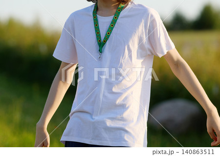 Person wearing sunflower lanyard indicating hidden disability outdoors 140863511