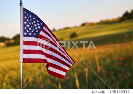 American flag waving in rural field during sunset American flag waving in rural field during sunset 140863522