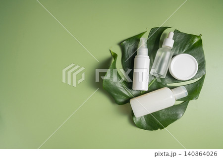 Natural skincare products on monstera leaf with green background, botanical clean beauty concept 140864026