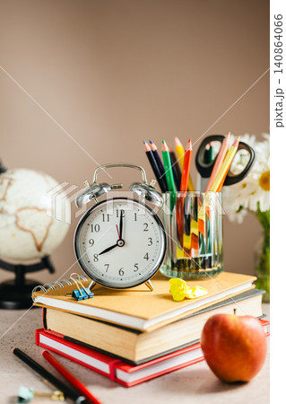 Academic planning with alarm clock on textbooks, study schedule concept Academic planning with alarm clock on textbooks, study schedule concept 140864066