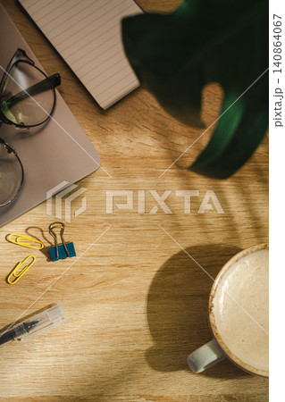 Coffee cup and laptop, with plant shadow on wooden desk, morning lifestyle background with copy space Coffee cup and laptop, with plant shadow on wooden desk, morning lifestyle background with copy space 140864067