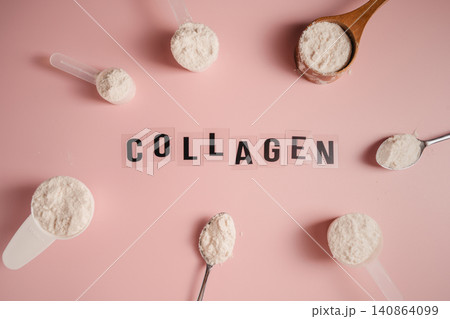Collagen powder scoops arranged around word collagen on pink background 140864099