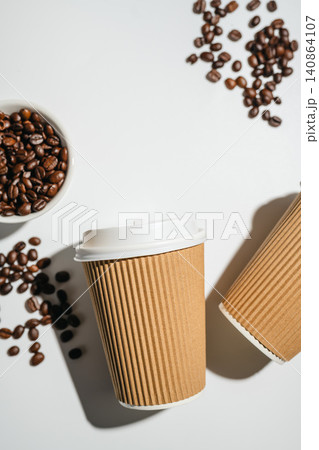 Takeaway coffee cups and roasted coffee beans on white background with copy space, flat lay 140864107