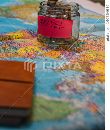Start a travel fund with savings jar on a world map for future trips Start a travel fund with savings jar on a world map for future trips 140864659