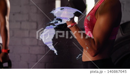 Interacting woman in pink bra, shorts using 3D globe in gym, gloved hand and red tracker Interacting woman in pink bra, shorts using 3D globe in gym, gloved hand and red tracker 140867045