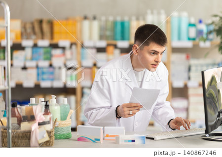 Young man pharmacist uses computer at workplace Young man pharmacist uses computer at workplace 140867246