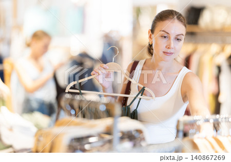 Young woman choosing dress in clothing store 140867269