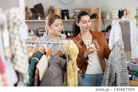 Two young women choosing outerwear in store Two young women choosing outerwear in store 140867569