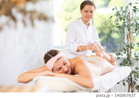 Young woman masseuse doing foot massage Young woman masseuse doing foot massage 140867637