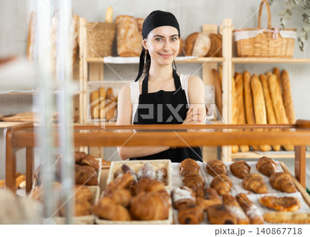 Young woman seller at showcase with pastries Young woman seller at showcase with pastries 140867718