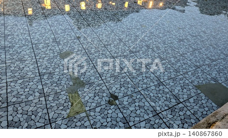 High angle full frame shot captures clean water rippling over a geometric gray mosaic stone tiled floor, creating beautiful reflections under soft evening illumination from small decorative square High angle full frame shot captures clean water rippling over a geometric gray mosaic stone tiled floor, creating beautiful reflections under soft evening illumination from small decorative square 140867860