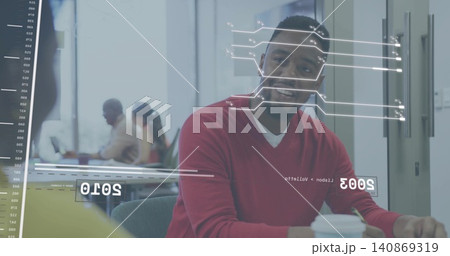 Smiling man in red sweater sitting at meeting table with glass AR graphics, holding coffee cup 140869319