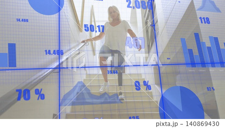 Descending senior woman holding handrail, stepping on stairs with prosthetic white-tee blue charts 140869430