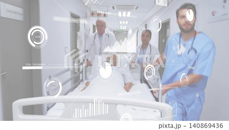 Wheeling patient on stretcher down hospital corridor, team in white coats and scrubs, HUD overlay 140869436