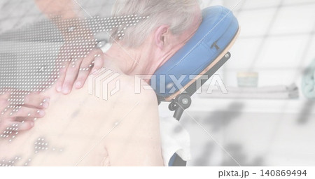 Therapist hands pressing shirtless man resting prone on chair in spa with blue cradle and towel 140869494