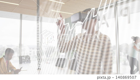 Pointing woman wearing VR headset and striped shirt reaching toward glass wall in office, tablet Pointing woman wearing VR headset and striped shirt reaching toward glass wall in office, tablet 140869507
