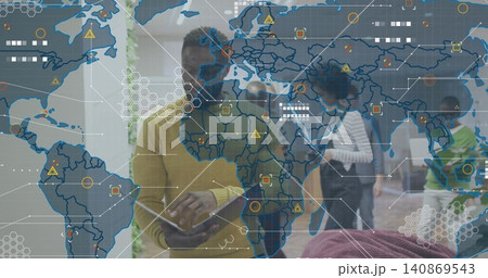 Holding tablet, mid adult man wearing mustard sweater using data overlay in open-plan office 140869543