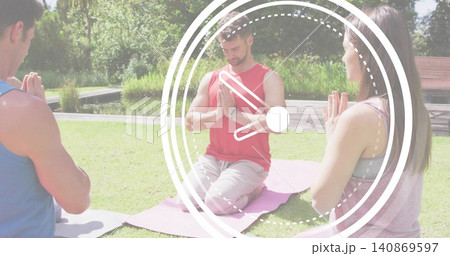 Kneeling central man wearing red sleeveless top pressing palms on pink mat near pond, clock overlay 140869597