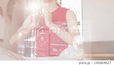Interacting woman in sleeveless red top using holographic UI panels at home lounge, data charts Interacting woman in sleeveless red top using holographic UI panels at home lounge, data charts 140869627