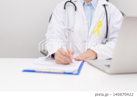 doctor using laptop and report notes on notebook for Gold Yellow Ribbon for concept of September Childhood Awareness month, July Sarcoma, bone and bladder, support survivor. World Cancer day doctor using laptop and report notes on notebook for Gold Yellow Ribbon for concept of September Childhood Awareness month, July Sarcoma, bone and bladder, support survivor. World Cancer day 140870422