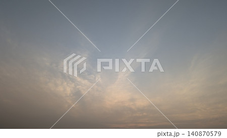 A horizontal wide angle perspective captures a beautiful clear sky filled with soft wispy clouds during a calm sunrise dawn period. The natural gradient color background creates a serene minimalist A horizontal wide angle perspective captures a beautiful clear sky filled with soft wispy clouds during a calm sunrise dawn period. The natural gradient color background creates a serene minimalist 140870579