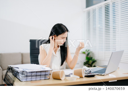 Stressed businesswoman working on laptop in a home office, facing workload, burnout and deadline pressure. Modern remote work, productivity and mental health concept. Stressed businesswoman working on laptop in a home office, facing workload, burnout and deadline pressure. Modern remote work, productivity and mental health concept. 140870659