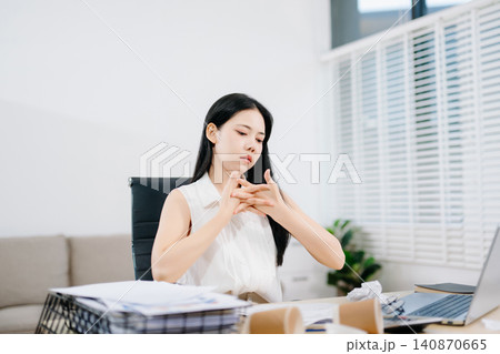 Young Asian woman suffering neck pain while working from home with laptop. Concept of stress, fatigue, burnout, workload and remote work challenges. 140870665