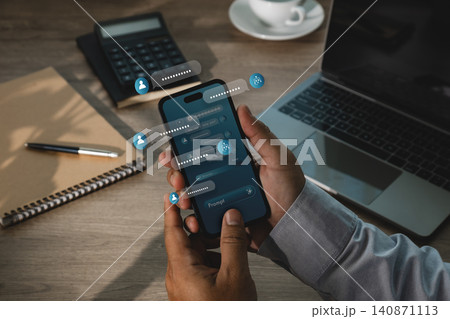 Hand uses smartphone with AI chatbot interface, floating message bubbles, prompt icons and laptop workspace, showing digital assistant communication and automation for business workflow. Hand uses smartphone with AI chatbot interface, floating message bubbles, prompt icons and laptop workspace, showing digital assistant communication and automation for business workflow. 140871113