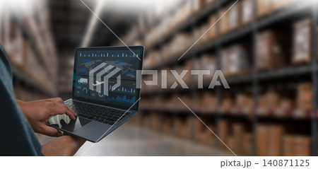 manager using a laptop with an AI logistics dashboard in a warehouse, showing supply chain, inventory, and transport analytics for monitoring operations, storage, and distribution performance. 140871125