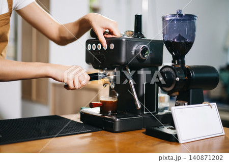 Cup and professional espresso machine pouring fresh coffee into a glass cup 140871202
